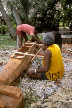 Homem fazendo canoa de madeira